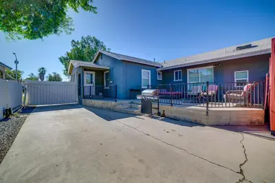 a blue house with a porch and a fence at Family-Friendly Home 2 Mi to Dtwn Riverside in Riverside