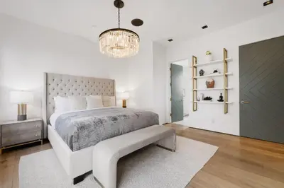 a bedroom with a large bed and a chandelier at Mulholland Edition in Beverly Hills