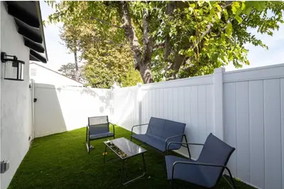 two chairs and a table on a lawn with a fence at Stellar Sherman Oaks One Bedroom close to Universal Studios in Burbank