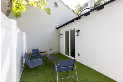 a patio with blue chairs and a table and a building at Stellar Sherman Oaks One Bedroom close to Universal Studios in Burbank