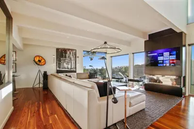 a living room with a couch and a tv at The Beverly Aura in Los Angeles
