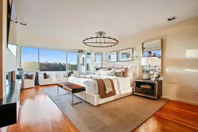a large bedroom with a white bed and a chandelier at The Beverly Aura in Los Angeles