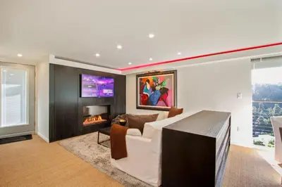 a living room with a couch and a fireplace at The Beverly Aura in Los Angeles