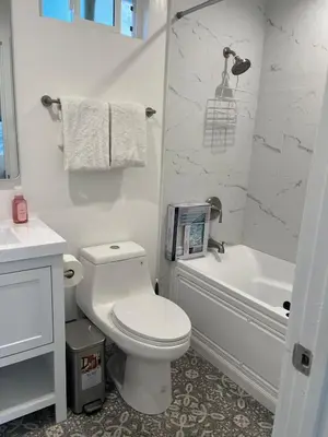 a white bathroom with a toilet and a bath tub at Brand New Home, Great Location, Monthly Discounts in Woodland Hills