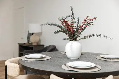 a table with plates and a vase with flowers on it at Serene Urban Haven in Los Angeles