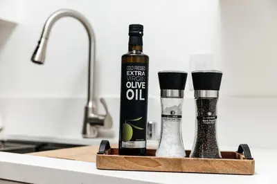 a bottle of oil and two wine glasses on a kitchen counter at Serene Urban Haven in Los Angeles