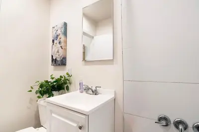 a white bathroom with a sink and a mirror at Affordable 1BR apt near Beverly Hills in Los Angeles
