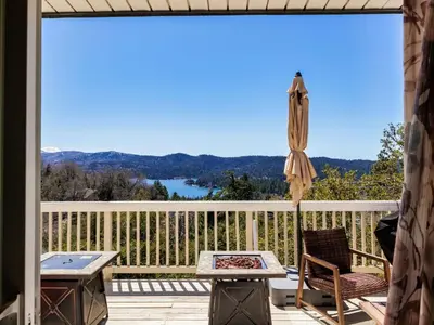 a patio with a table and an umbrella on a deck at Holiday Home Haus mit Seeblick - Atemberaubende Aussicht - Haustierfreundlich by Interhome in Lake Arrowhead
