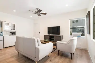 a living room with two chairs and a flat screen tv at Freshly Renovated Studio for Two in the Heart of LA in Los Angeles
