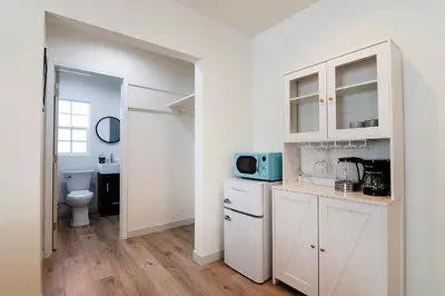 a white kitchen with a sink and a microwave at Freshly Renovated Studio for Two in the Heart of LA in Los Angeles