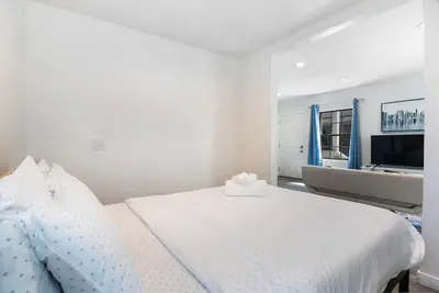 a white bedroom with a large bed and a sink at Upper-Level Studio Suite Close to Beverly Hills in Los Angeles
