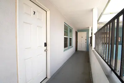 an empty hallway with a white door and windows at Cozy Studio Suite Near Beverly Hills for Two in Los Angeles