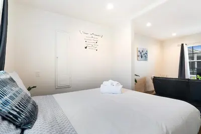 a bedroom with a large white bed and a window at Cozy Studio Suite Near Beverly Hills for Two in Los Angeles