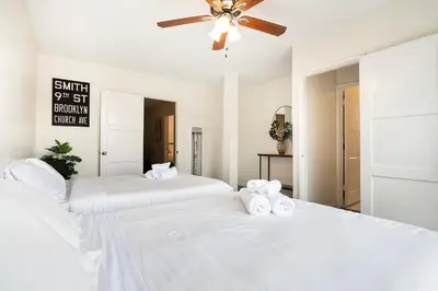 two beds in a white bedroom with a ceiling fan at Comfortable 1B 2beds Retreat Near Beverly Hills in Los Angeles