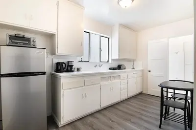a kitchen with white cabinets and a white refrigerator at Comfortable 1B 2beds Retreat Near Beverly Hills in Los Angeles