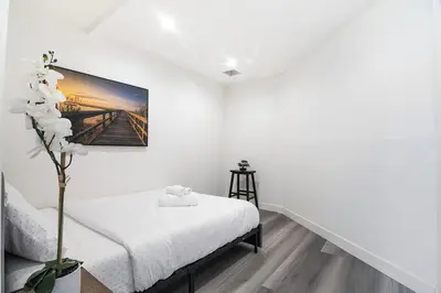 a white room with a bed and a picture on the wall at Comfortable 2Bedroom apartment close to Beverly Hills in Los Angeles
