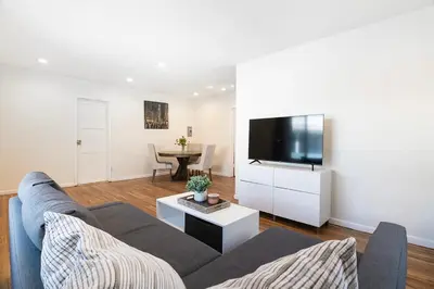 a living room with a couch and a flat screen tv at Comfortable One-Bedroom with Two Queen Beds in Los Angeles
