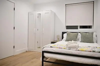 a bedroom with a large bed with white walls at Calm Luxe Ensuite Room near USC-Shared Home in Los Angeles