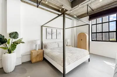 a bedroom with a canopy bed and a plant at DTLA Boutique Loft w Rooftop Pool Hot Tub in Los Angeles