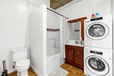 a bathroom with a washing machine and a toilet at DTLA Boutique Loft w Rooftop Pool Hot Tub in Los Angeles