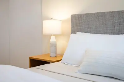 a bedroom with a bed with a lamp on a table at Stylish LA Retreat Near Disney Knotts SoFi in Paramount