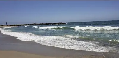 a beach with some waves in the ocean at Luxe Beachside Escape Near Channel Islands in Oxnard