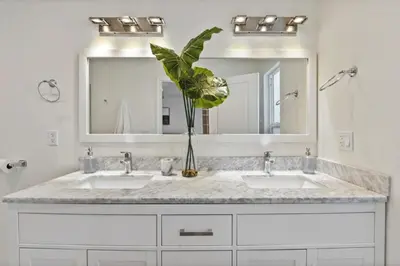 a bathroom with two sinks and a large mirror at Charming Encino Retreat with Pool in Encino