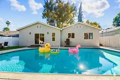 a swimming pool with three rubber ducks in the water at Charming Encino Retreat with Pool in Encino