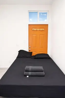 a bed in a room with an orange door at Pickford Vibe near Beverly Hills in Los Angeles