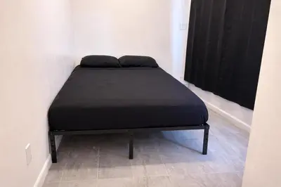 a black bed in a room with a window at Pickford Vibe near Beverly Hills in Los Angeles