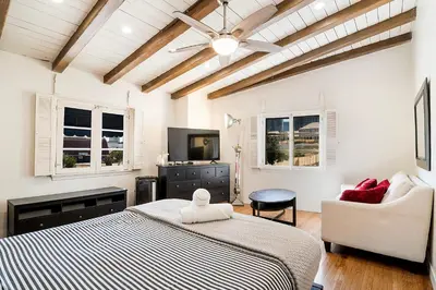 a bedroom with a bed and a couch and a tv at Cozy Beverly Hills Studio Near Shopping with Kitchen in Los Angeles