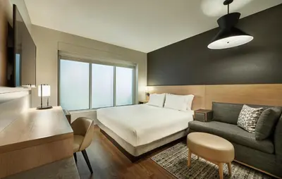 a hotel room with a bed and a couch at Hyatt Place Ontario Airport in Ontario