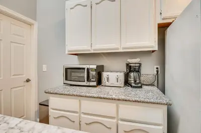 a kitchen with white cabinets and a counter with a microwave at Melrose Hill Home Near Hospitals Nurses Welcome! in Los Angeles