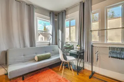 a living room with a couch and a table and windows at Melrose Hill Home Near Hospitals Nurses Welcome! in Los Angeles