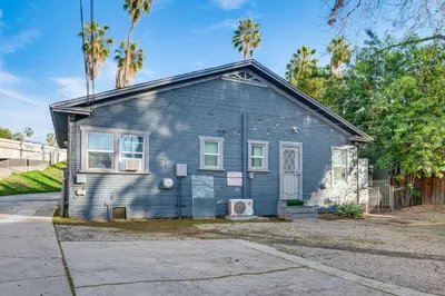 a blue house with palm trees in front of it at Melrose Hill Home Near Hospitals Nurses Welcome! in Los Angeles
