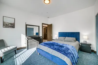 a bedroom with a blue bed and a couch at Fully Updated! Prime Riverside Spot Near Dtwn in Riverside