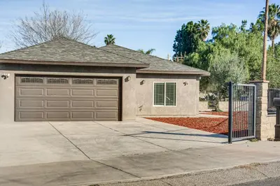 a house with a garage door and a driveway at Fully Updated! Prime Riverside Spot Near Dtwn in Riverside