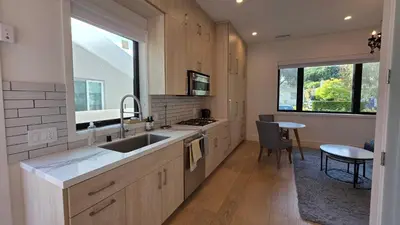 a kitchen with a sink and a counter with a table at Modern Studio with Kitchen Parking Near Beverly Hills and Culver City in Los Angeles