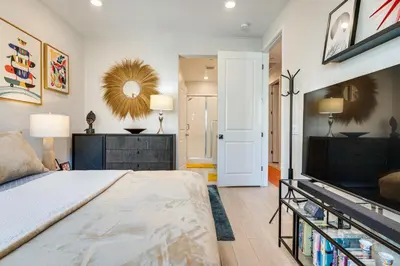 a bedroom with a large bed and a tv at 12 Mi to DTLA! Multi-Level Charmer with Pool Access in Montebello