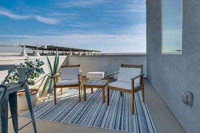 a patio with a table and chairs on a balcony at 12 Mi to DTLA! Multi-Level Charmer with Pool Access in Montebello