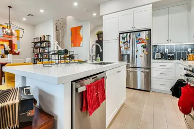 a kitchen with white cabinets and a red towel at 12 Mi to DTLA! Multi-Level Charmer with Pool Access in Montebello