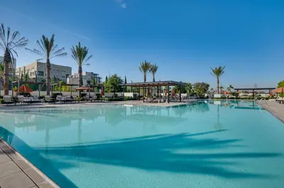 a large swimming pool in a resort with palm trees at 12 Mi to DTLA! Multi-Level Charmer with Pool Access in Montebello