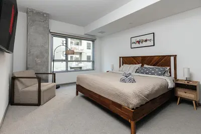 a bedroom with a bed and a chair and a window at Spacious 2bedroom in Hollywood with Parking Gym Pool in Los Angeles