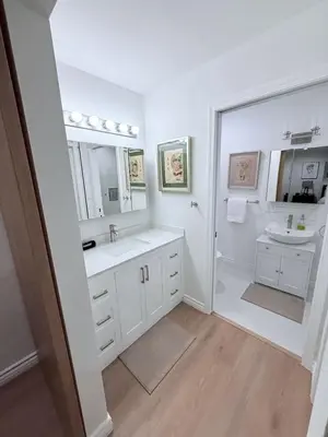 a white bathroom with two sinks and a mirror at Private 3BR Home - Hot Tub, Yard, Arcade & Parking in Simi Valley