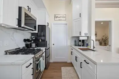 a kitchen with white cabinets and a stove top oven at Luxury 1BR Suite Kitchen, Fireplace, Laundry, BBQ in Simi Valley