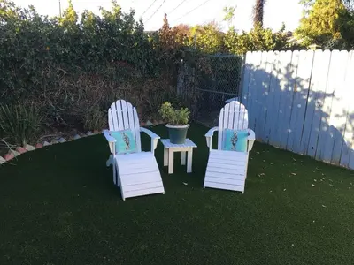 two white chairs and a table in a yard at Cozy Villa with Spa, Fireplace, Kitchen, Yard, BBQ in Simi Valley