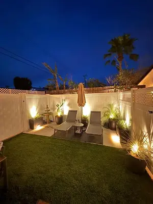 a garden with two chairs and an umbrella at night at 2BR 2BA Home Hot Tub, Firepit, Yard, BBQ, Parking in Simi Valley