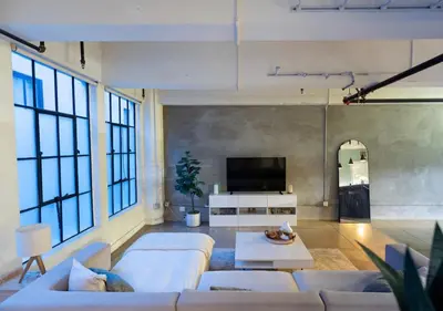 a living room with a couch and a tv at Chic urban loft steps from dining and shopping in Los Angeles