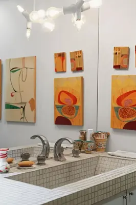 a kitchen with two faucets and paintings on the wall at New Listing Modern Hollywood Hills Sanctuary by Colby & Conrad in Los Angeles
