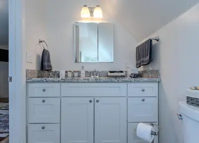 a white bathroom with a sink and a mirror at Luxury Lakefront Retreat,HotTub,EV Charge,Fire Pit in Big Bear Lake